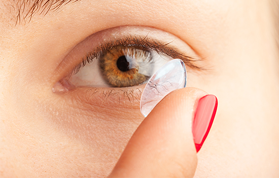 contact-lens Woman applying contact lens to her eye